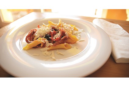 Garganelli Romagnola servert med tomater, tørket skinke, Tagiascca oliven og lagret Riccotta ost